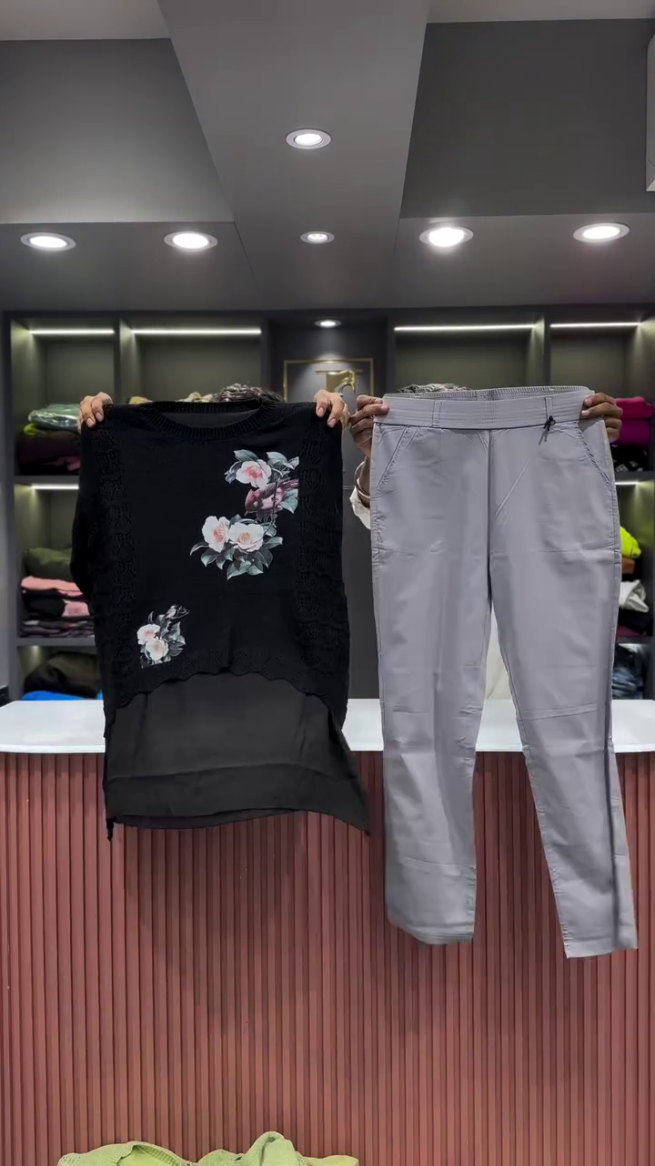 Black Open-Knit Top with Floral Appliqués and Gray Pants