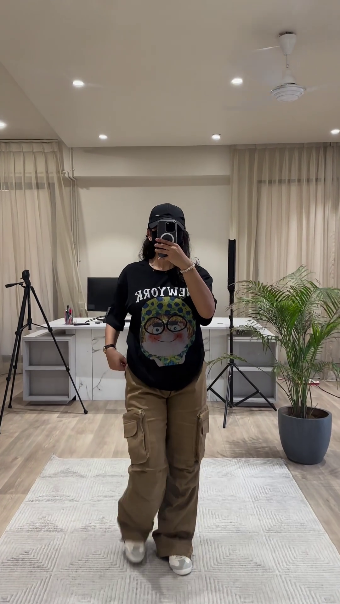 Urban Chic Outfit: White Graphic Tee, Rust Cargo Pants, and Black Cap - Image 2