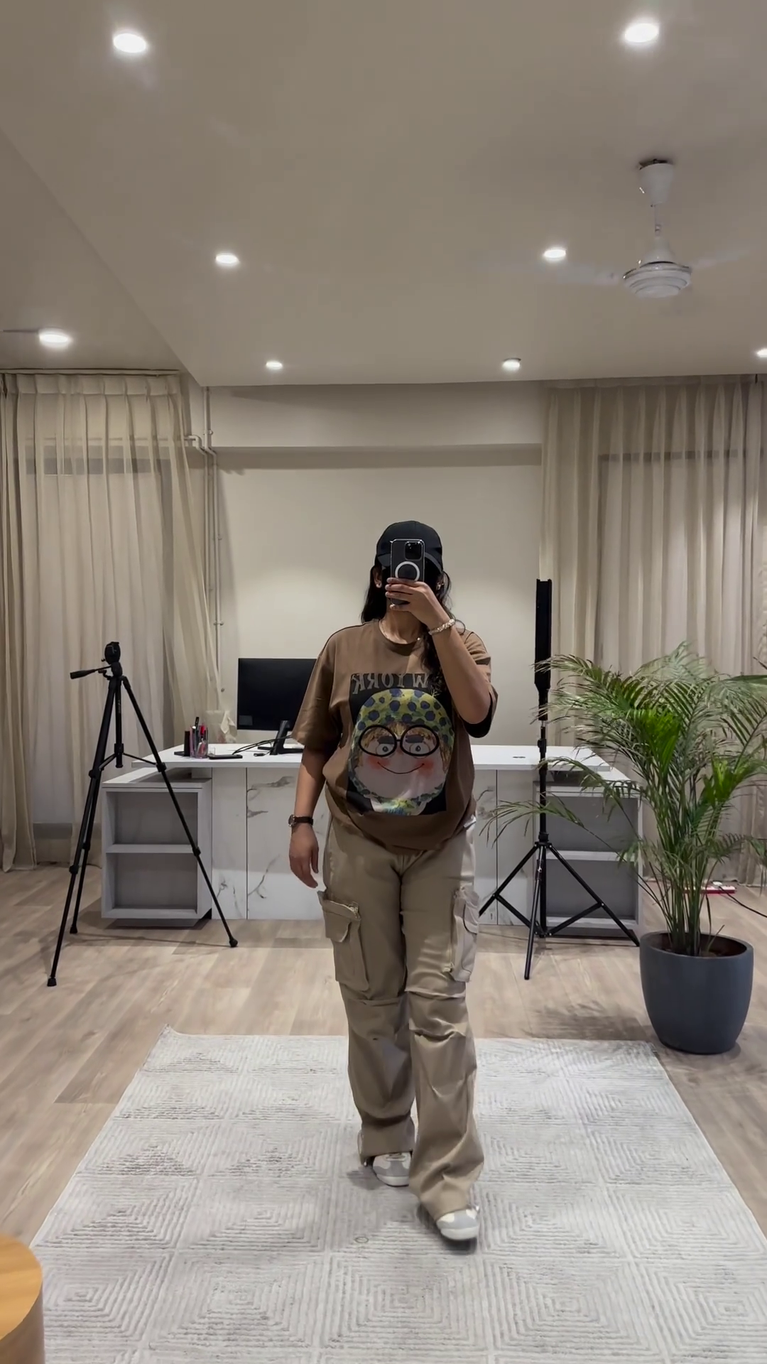 Urban Chic Outfit: White Graphic Tee, Rust Cargo Pants, and Black Cap - Image 3