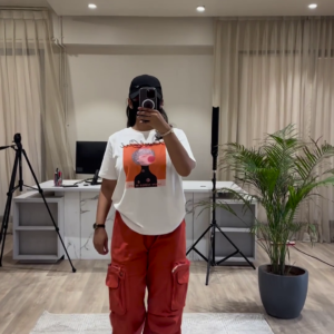 Urban Chic Outfit: White Graphic Tee, Rust Cargo Pants, and Black Cap