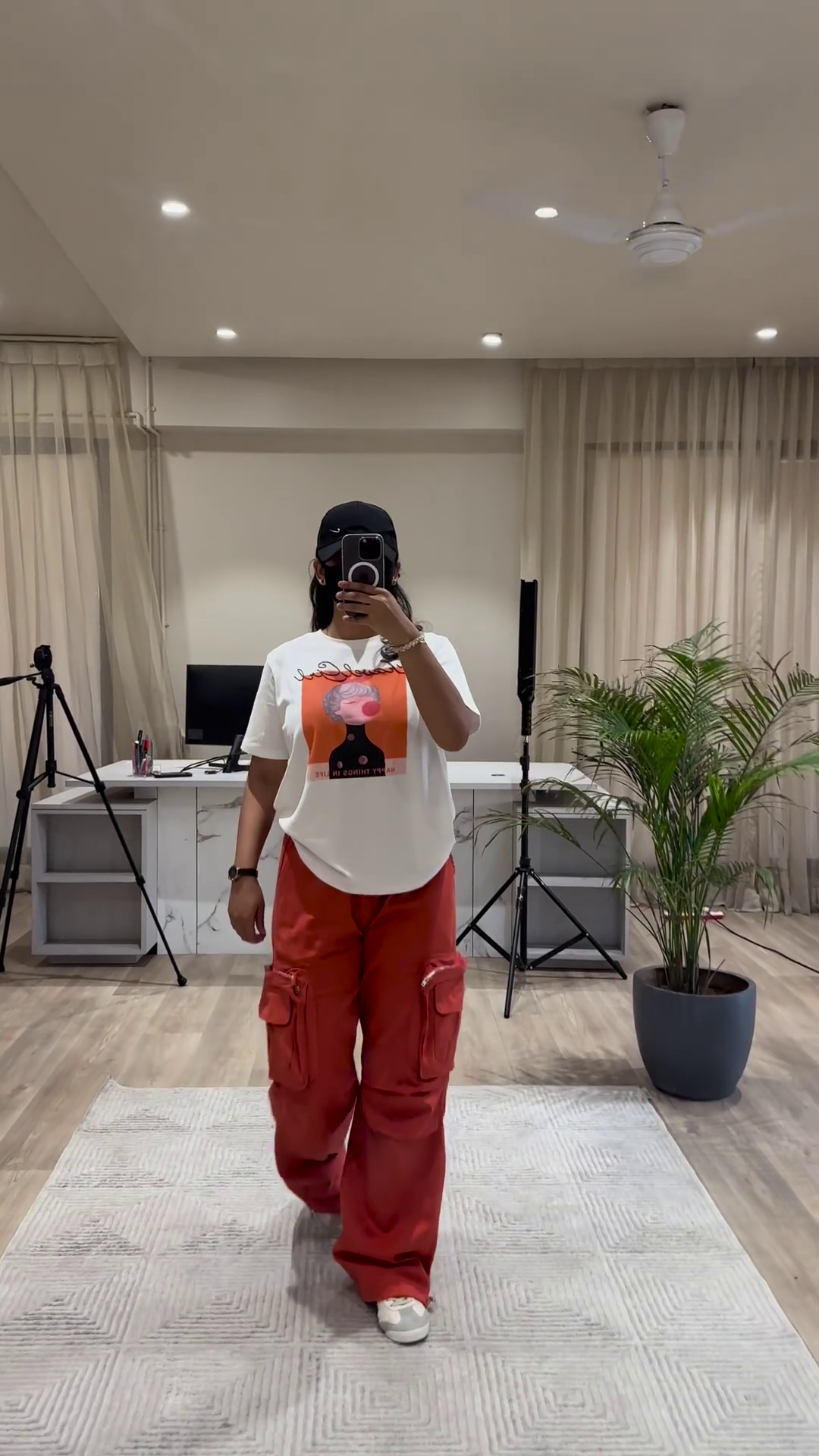 Urban Chic Outfit: White Graphic Tee, Rust Cargo Pants, and Black Cap